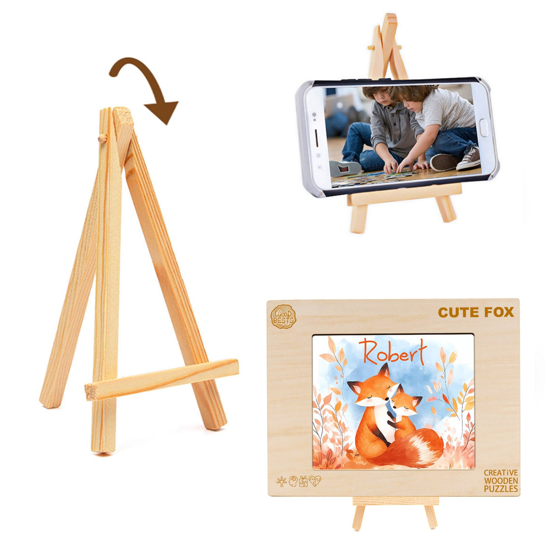 Wooden easel displaying a puzzle featuring a cute fox and a child's name, alongside a phone holder.