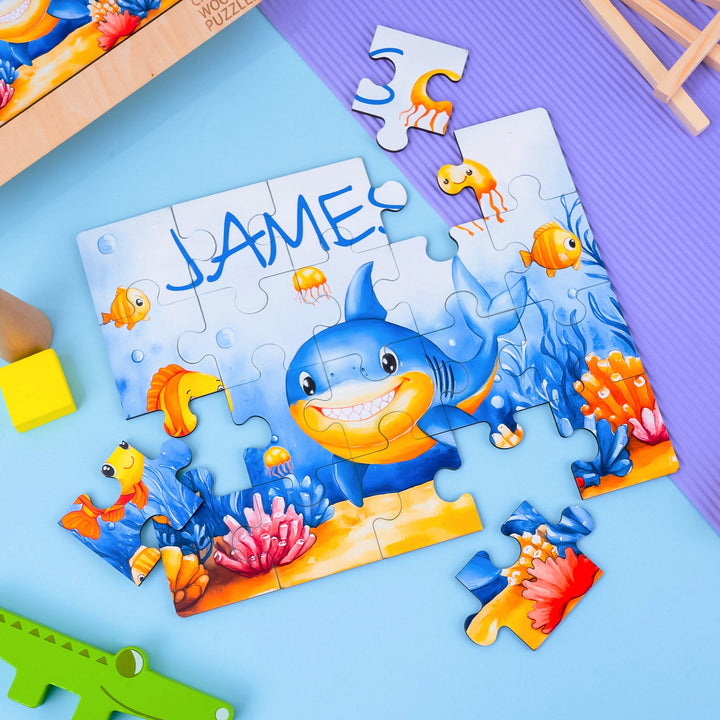 Colorful children's wooden jigsaw puzzle featuring a shark and sea creatures, personalized with the name 'JAME'.