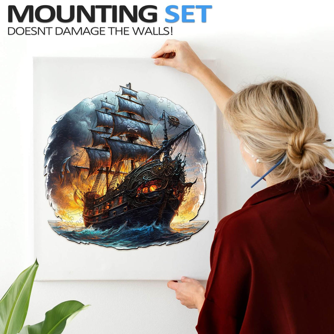 Person mounting a vibrant sailing ship artwork on a wall with a wall-friendly mounting set.