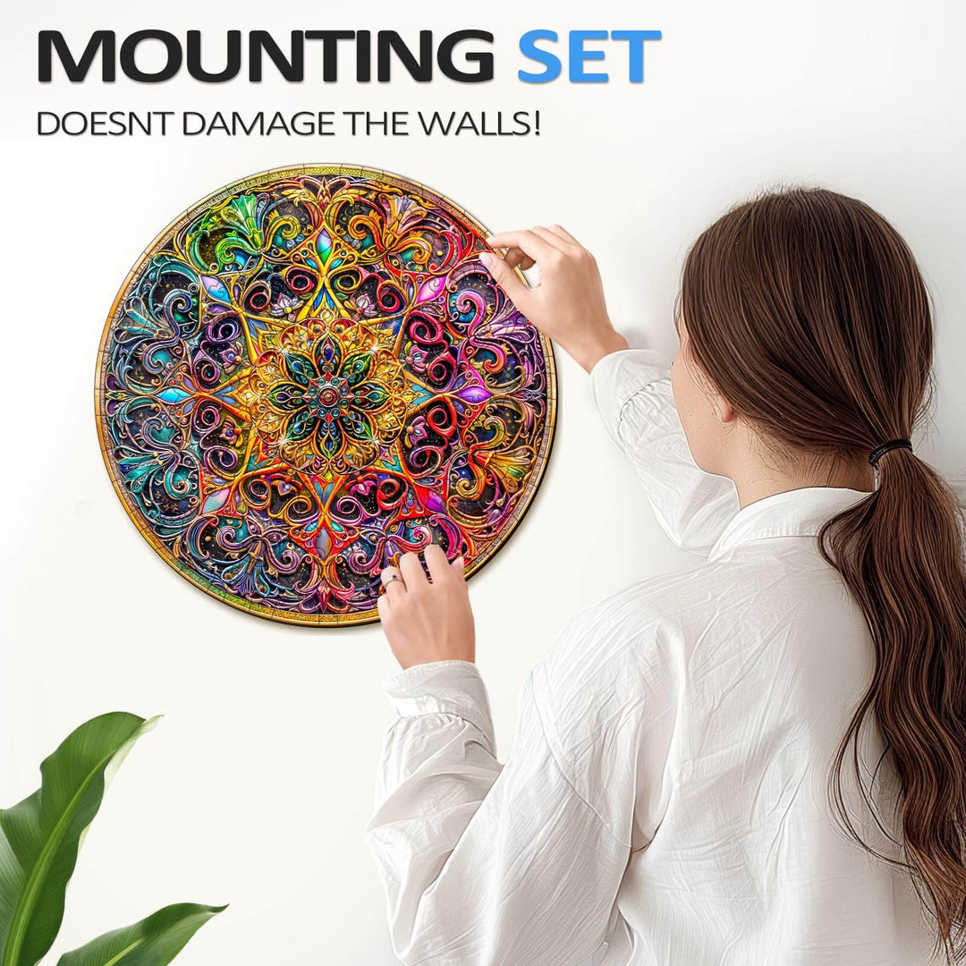 Woman using a mounting set to hang a colorful Mandala Dreamland jigsaw puzzle on a wall without damage.