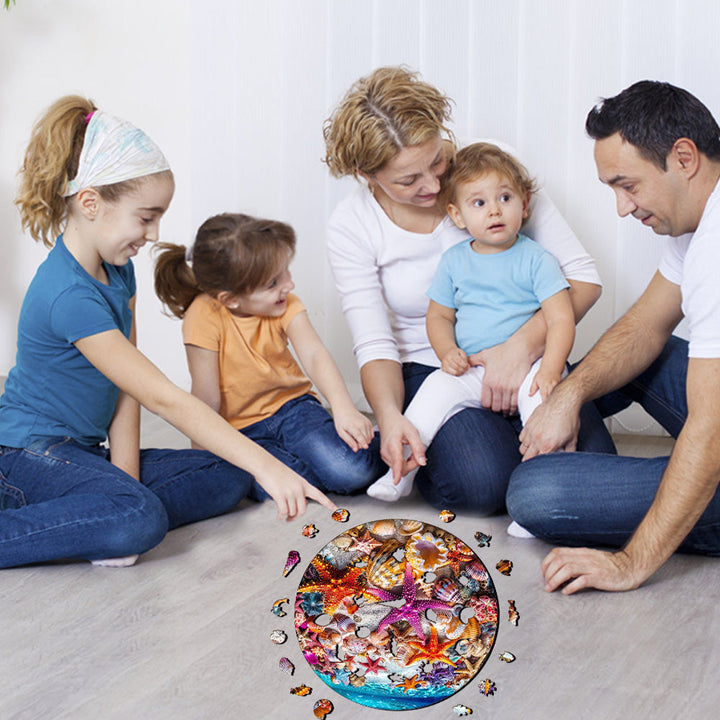 Family enjoying time together while solving a Starfish wooden jigsaw puzzle on the floor.
