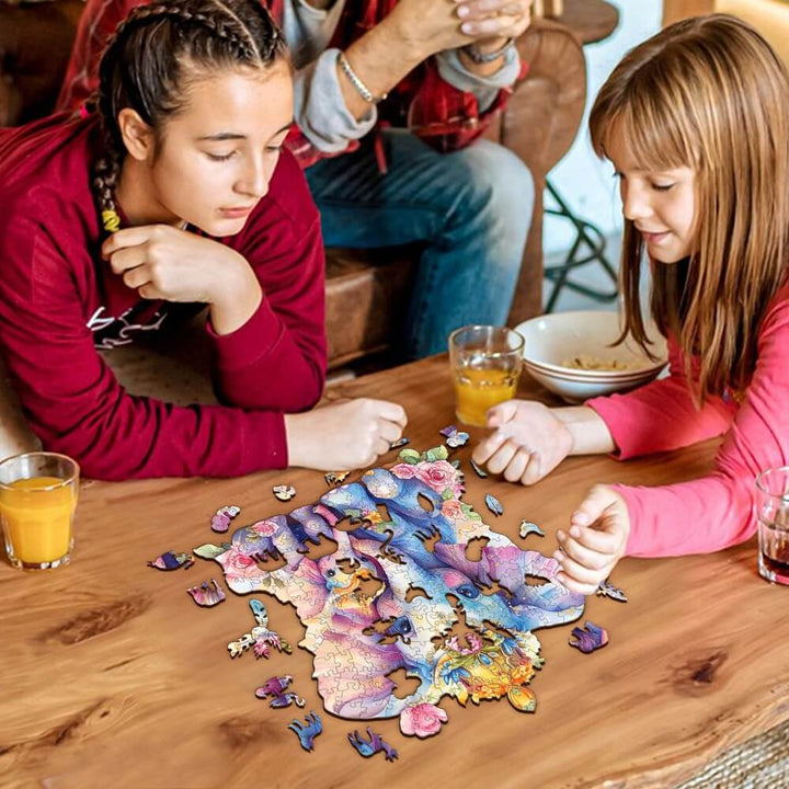 Two girls focusing intently on assembling a colorful parent child elephant wooden jigsaw puzzle on a table.