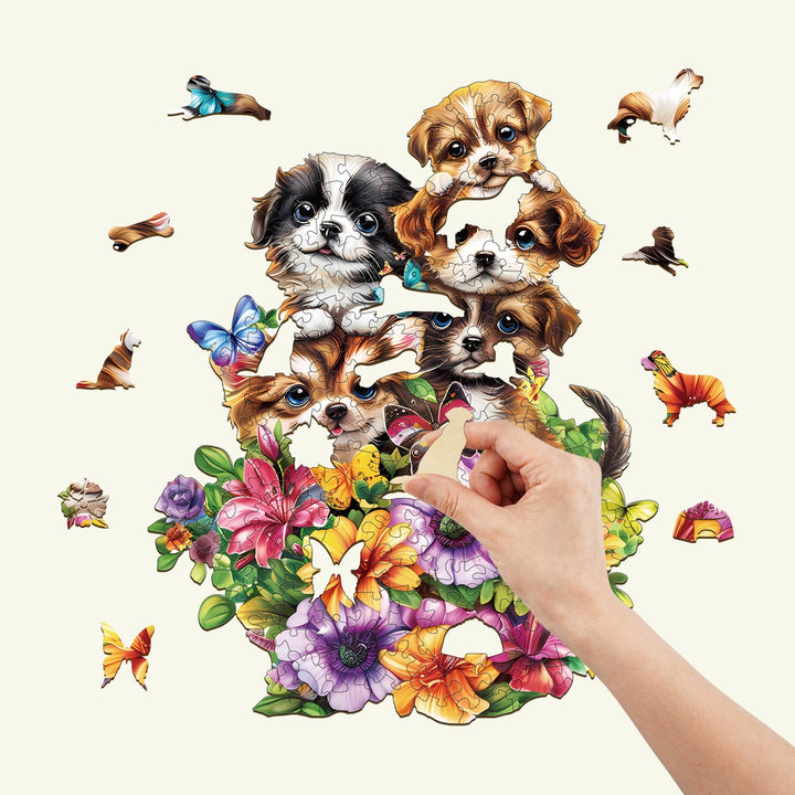 Hand completing a Cute Dogs wooden jigsaw puzzle surrounded by colorful flowers and butterflies.